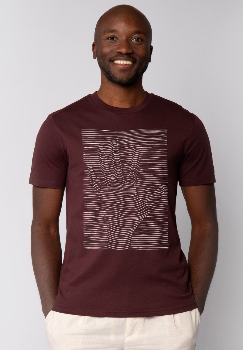 Bordeaux katoenen t-shirt met een textuur design van een witte hand, gemaakt met horizontale lijnen. Korte mouwen en een ronde hals.