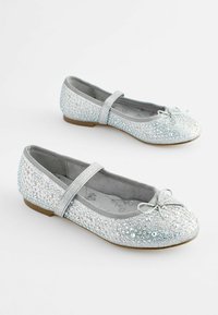 Bailarinas plateadas con rhinestones brillantes, suelas planas, forro de tela y un lazo decorativo en la punta, con una correa cruzando el tobillo.