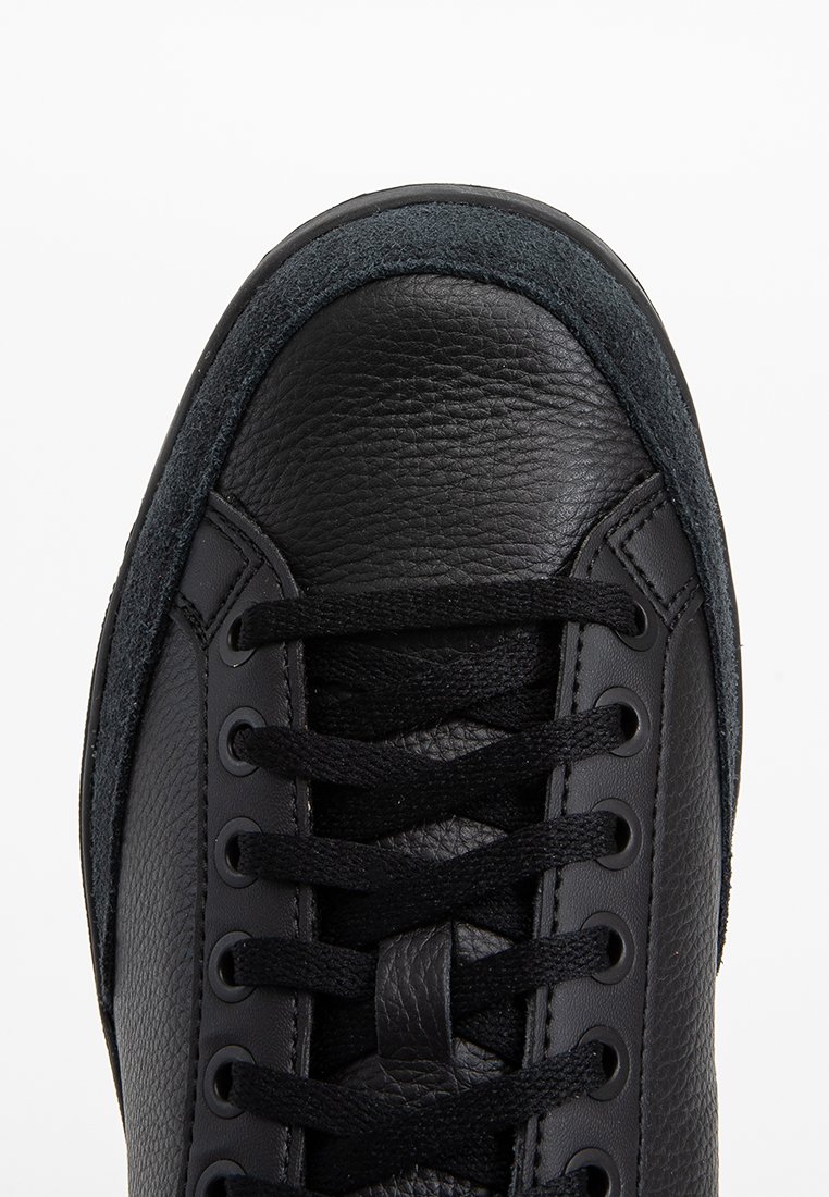 Czarne skórzane sneakersy z gładkim czubkiem, teksturowanymi bocznymi panelami i okrągłymi czarnymi sznurowadłami.  Z akcentem z zamszu w okolicy kołnierza.