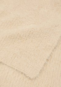 Tessuto lavorato a maglia color crema con trama a coste e fibre morbide e pelose, mostrato in una vista ravvicinata.