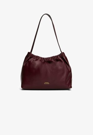 Borsa in pelle bordeaux con parte superiore arricciata e tracolla singola. Presenta un logo dorato nella parte inferiore, una texture liscia e un design minimalista.