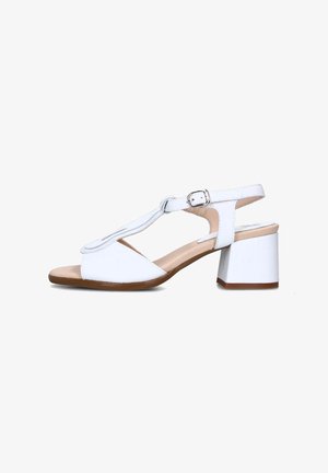 Sandalo bianco con apertura sulla punta, design a T-strap, fibbia alla caviglia regolabile e tacco a blocco. Texture liscia con suola marrone chiaro.