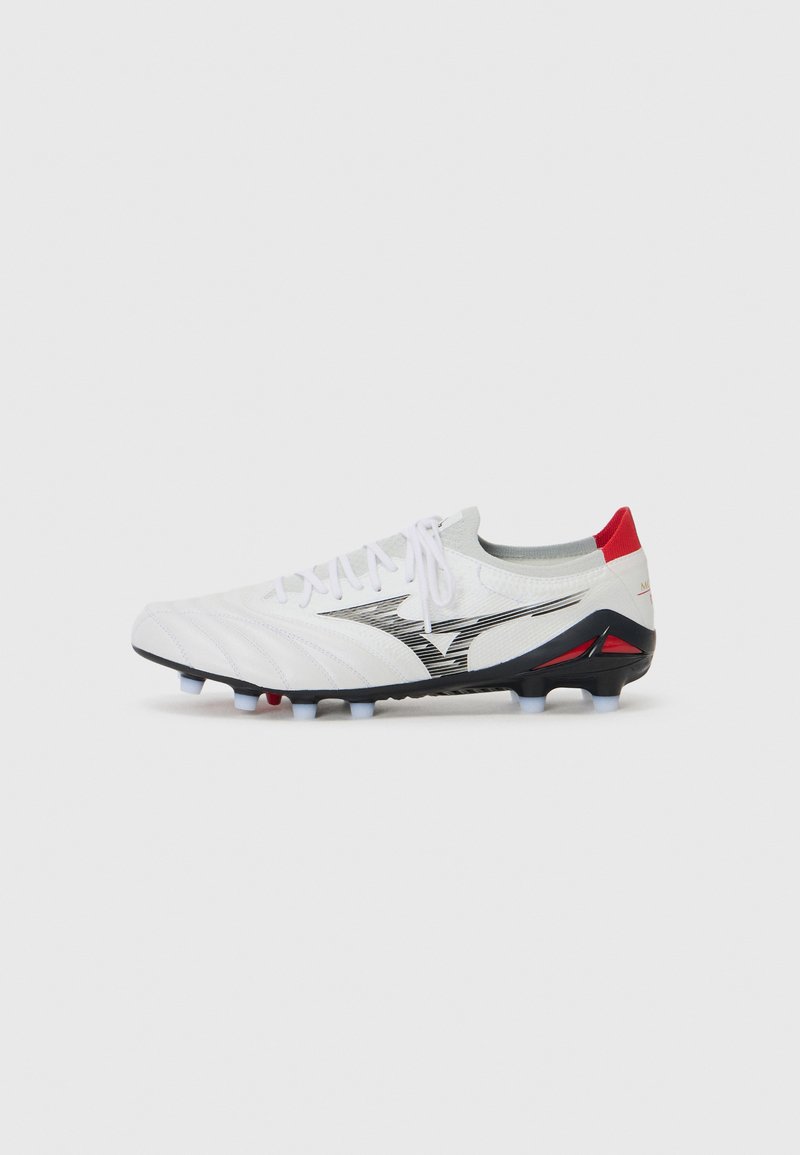 Witte voetbalschoenen met een gestructureerde bovenkant met diagonale strepen, zwarte accenten en een rode hiel; plastic noppen voor grip.