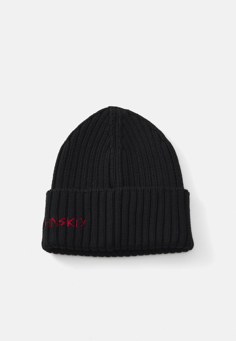 Zwarte geribbelde gebreide beanie met een omgeslagen rand. Bevat rode geborduurde tekst op de zijkant. Zachte textuur en cilindervorm.