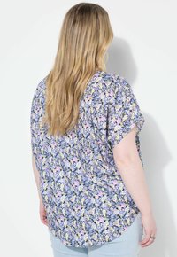 Blusa floreale a maniche corte in blu navy, caratterizzata da un motivo di fiori multicolore, in tessuto morbido, dalla vestibilità rilassata e con orlo arrotondato.