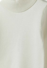 Cremfarbener Rollkragenpullover mit einem gerippten Kragen, glatter Textur und leichtem Material, das eine taillierte Passform aufweist.