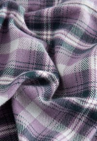 Plaid fabric in shades of lavender, white, and dark green, featuring a soft texture with a subtle, warm pattern.