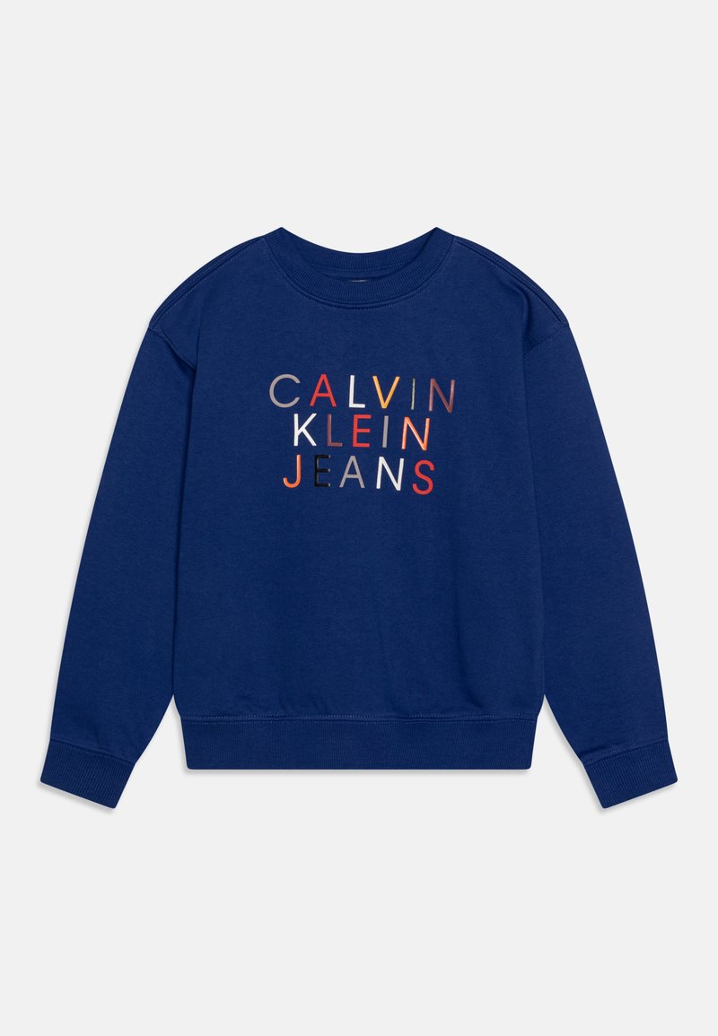 Tamsiai mėlynas džemperis su priekiniais užrašais "CALVIN KLEIN JEANS" daugiaspalvėmis raidėmis. Minkšta medžiaga, su guma aptrauktomis rankovėmis ir iškirpte.