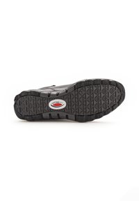 Semelle de chaussure en caoutchouc noir avec un motif texturé, présentant un logo proéminent et des rainures flexibles pour une traction et un soutien.