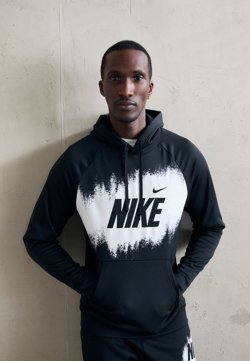 Svart og hvit Nike hettegenser med gradientmønster, stor logo på brystet, snorhette og glatt, elastisk stoff.