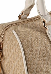 Beige gestructureerde handtas met een monogrampatroon, een gouden ritssluiting en witte leren accenten. Voorzien van stevige handvatten en decoratieve hardware.