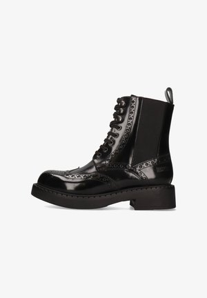 Stivaletto in pelle verniciata nera con dettagli brogue, chiusura lace-up, pannello elastico, linguetta per il pull e tacco spesso per stabilità.
