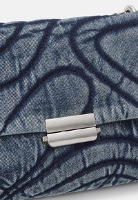 Borsa a pochette in denim con una superficie blu testurizzata, dotata di una chiusura metallica argentata e dettagli impuntati in blu scuro.