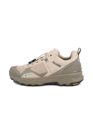 Πεζοπορικό παπούτσι Palladium Gore-Tex σε μπεζ και ελιά με σόλα Vibram και σύστημα γρήγορου δέσιμου κορδονιών, με ορατά λογότυπα στη πλευρά και την πτέρνα.