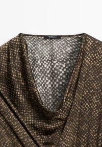 Tessuto a strisce marrone e beige con scollatura drappeggiata e etichetta Massimo Dutti, prodotto in Marocco.