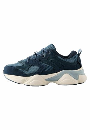 Mørkeblå sneakers med net- og ruskindsmaterialer, der har en tyk cremegul sål, teksturerede accenter og en kontrasterende lyseblå detalje.