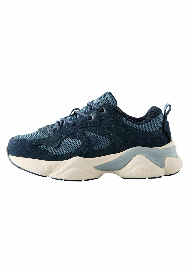 Baskets bleu foncé en matériaux en mesh et en suède, avec une semelle épaisse de couleur crème, des accents texturés et un détail contrastant en bleu clair.