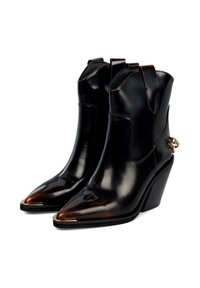 Botas de cuero negras hasta el tobillo con punta afilada, tacón en cuña, costuras laterales y un acento de hardware dorado en el tacón. Textura suave y diseño elegante.