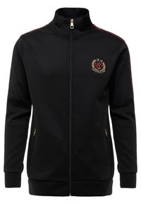 Black zip-up jacket made of soft fabric, featuring red shoulder stripes, gold zipper, and an embroidered logo on the left chest.