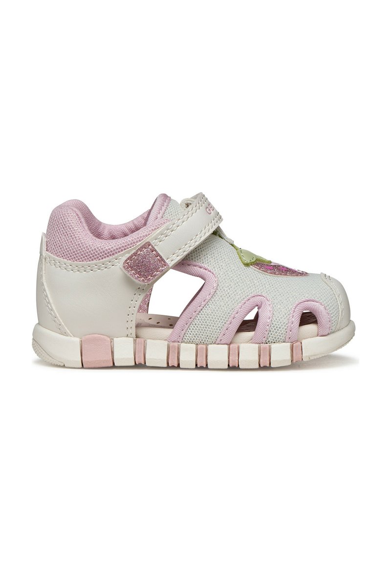 Sandalia blanca y rosa para niño pequeño con tira ajustable de Velcro, laterales de malla, punta cerrada, parche decorativo con purpurina y suela flexible.