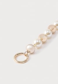 Brățară cu mărgele din perle lucioase în nuanțe de crem și auriu, prevăzută cu o închizătoare rotundă din metal auriu pentru prindere.