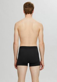 Schwarze Boxershorts mit einem weichen, elastischen Bund, aus einem glatten, dehnbaren Stoff gefertigt, der eng an den Oberschenkeln anliegt.