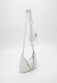 Borsa a tracolla bianca trapuntata realizzata in materiale sintetico. Caratterizzata da una tracolla in catena argentata e una tracolla staccabile con dettagli del logo.