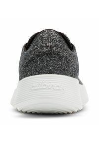 Černé a šedé pletené tenisky s texturovaným svrškem, bílé drážkované podrážky a logem na patě. Zakulacený tvar s těsným fit na zadní části.