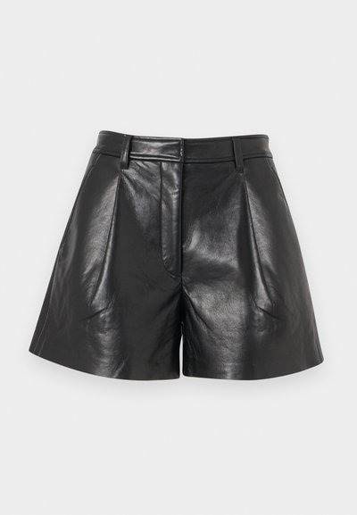 Čierne krátke nohavice z umelej kože s vysokým pásom, záhybmi, slučkami na opasok a predným zapínaním na klapku na svetlosivom pozadí.
