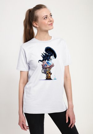 Hvid T-shirt med et farverigt design af en tegneseriefigur med en stor hjelm og et væsen, der viser blå og sorte accenter.