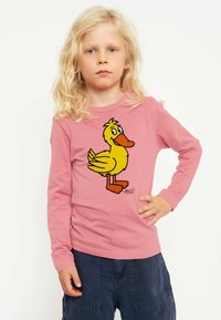 Rosa Langarmhemd mit einem Cartoon-Grafik eines gelben Entchens. Aus weichem Baumwollmaterial, Rundhalsausschnitt und lässiger Passform.