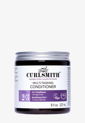 Curlsmith Multi-Tasking Conditioner i en 8 oz mørk krukke med sølv låg; har hvide og lilla etiketter til produktspecifikationer og vegansk certificering.