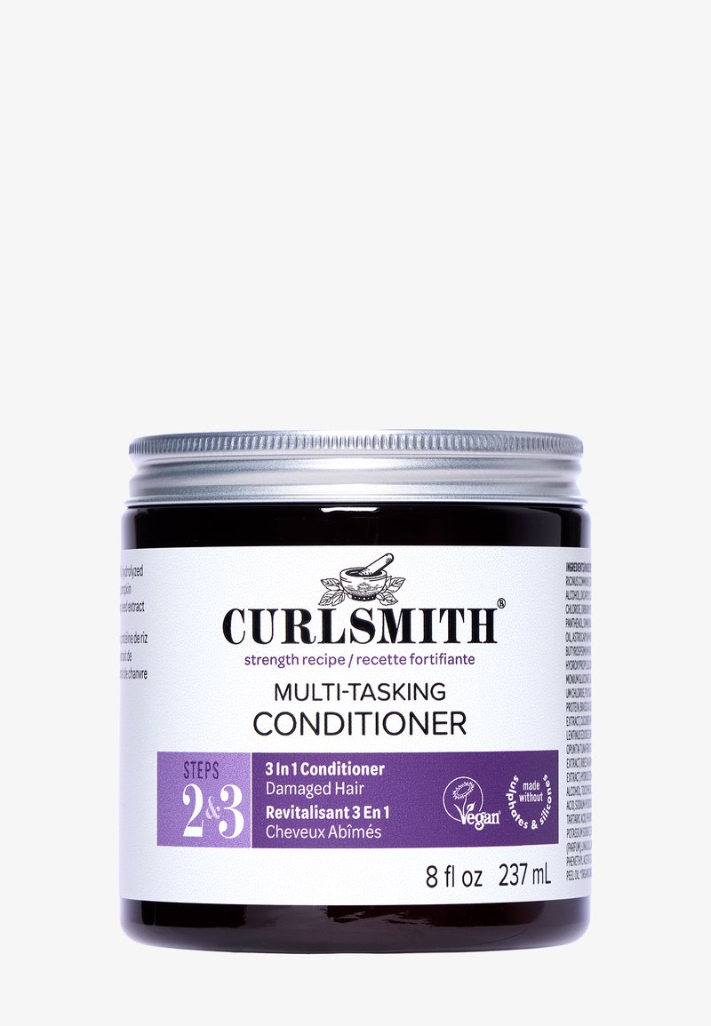 Curlsmith Multi-Tasking Conditioner i en 8 oz mørk krukke med sølv låg; har hvide og lilla etiketter til produktspecifikationer og vegansk certificering.