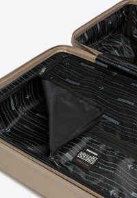 Open beige koffer met zwarte binnenvoering en reisthema-patronen, rits mesh pocket en stoffen scheidingsflap.