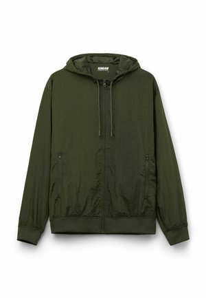 Chaqueta con capucha ligera en verde oscuro. Confeccionada en tejido texturizado, cuenta con una cremallera completa, capucha ajustable con cordón y dos bolsillos laterales.