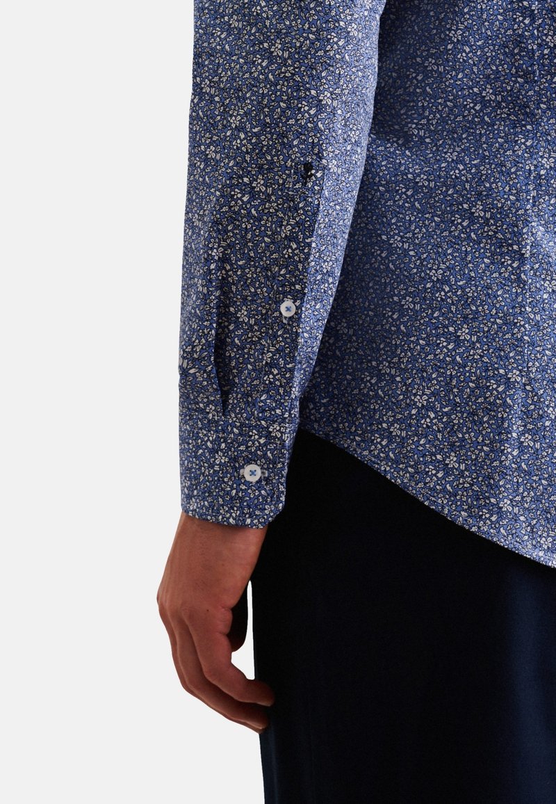 Camicia a maniche corte blu con motivo floreale, realizzata in cotone texturizzato, con piccoli motivi bianchi e gialli e bottoni bianchi sui polsini.