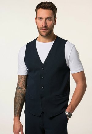 Marineblaues Weste mit taillierter Passform, einreihigem Design, fünf Knöpfen und zwei Seitentaschen, getragen über einem weißen T-Shirt.