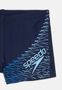 Calções de banho Speedo cor azul-marinho com padrão zigzag em azul-claro e logótipo Speedo na parte inferior.