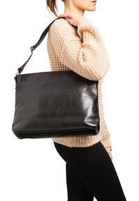 Zwarte leren handtas met een gladde textuur, rechthoekige vorm en een lange verstelbare schouderband. Heeft een subtiele glans en minimale hardware.