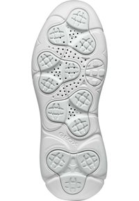 Suela de goma blanca con un patrón de panal que incluye orificios de ventilación, secciones de agarre texturizado y un logotipo en relieve en el talón.