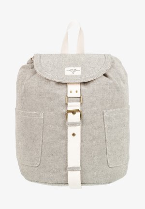 Sac à dos en tissu gris clair texturé avec rabat avant, sangle blanche avec boucle en laiton, poches latérales et boucle de poignée supérieure.