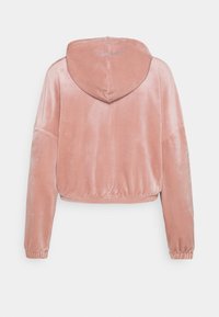 Cappotto corto in velluto rosa con tasca frontale, maniche ampie e cappuccio con coulisse. Texture liscia e dettagli con elastico in vita.