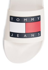 Sandale blanche à bride avec un logo Tommy Jeans noir, blanc et rouge sur le dessus.
