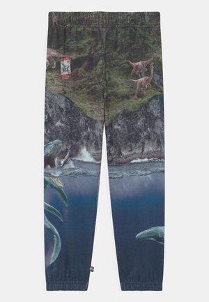 Bukser, der viser en klippe med dinosaurer og et "Fare"-skilt over vandet, hvor en stor havreptil og en hval svømmer.