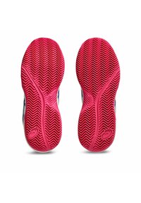 Semelles en caoutchouc rouge avec un motif de semelle en chevrons, dotées d'un dessus blanc lisse avec des accents bleus, conçues pour des activités athlétiques.