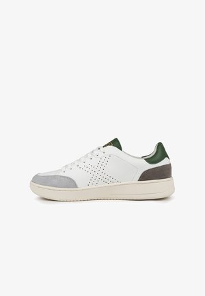 Sneaker bianca con punta in suede grigia, accento verde sul tallone e motivo a stelle perforate sui lati. La suola in gomma offre aderenza.