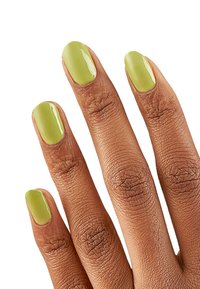 Smalto verde sulle cinque unghie, lucido e ben rifinito. Le unghie hanno una forma ovale con una superficie liscia che si staglia su una pelle leggermente texture.