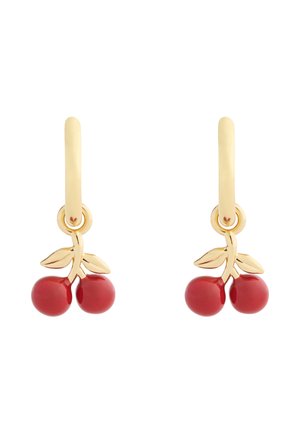 Boucles d'oreilles créoles en or avec des pendentifs en forme de cerises rouges et deux petites feuilles en or sur chaque pendentif, sur fond blanc.