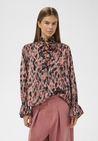 Langærmet bluse i pink stof med sort leopardprint, med høj flæsekant og udvidede manchetter, glat tekstur.