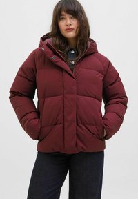 Burgundská péřová bunda s kapucí, prošívaný design, přední kapsy a zapínání na zip; obsahuje zelené kovové doplňky.